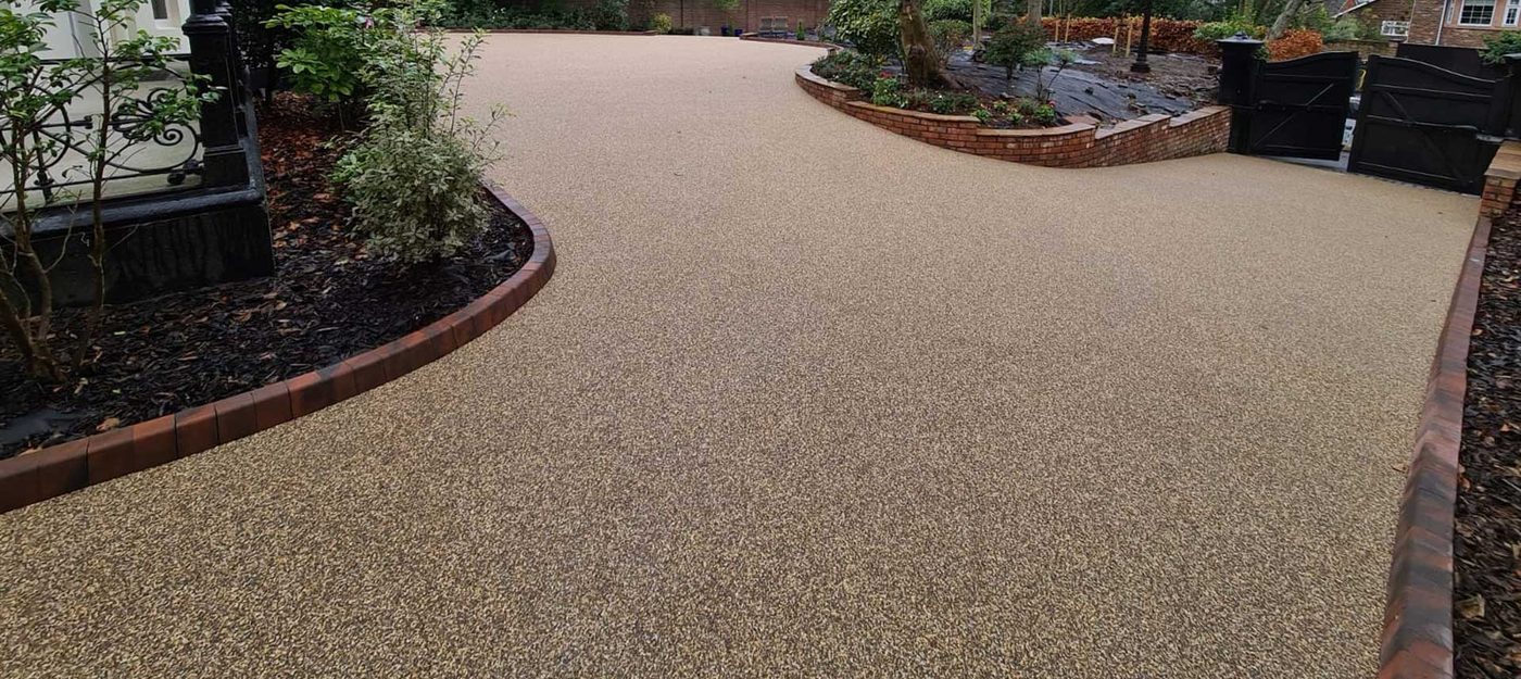 Finished golden resin bound driveway with brick edging and landscaped borders